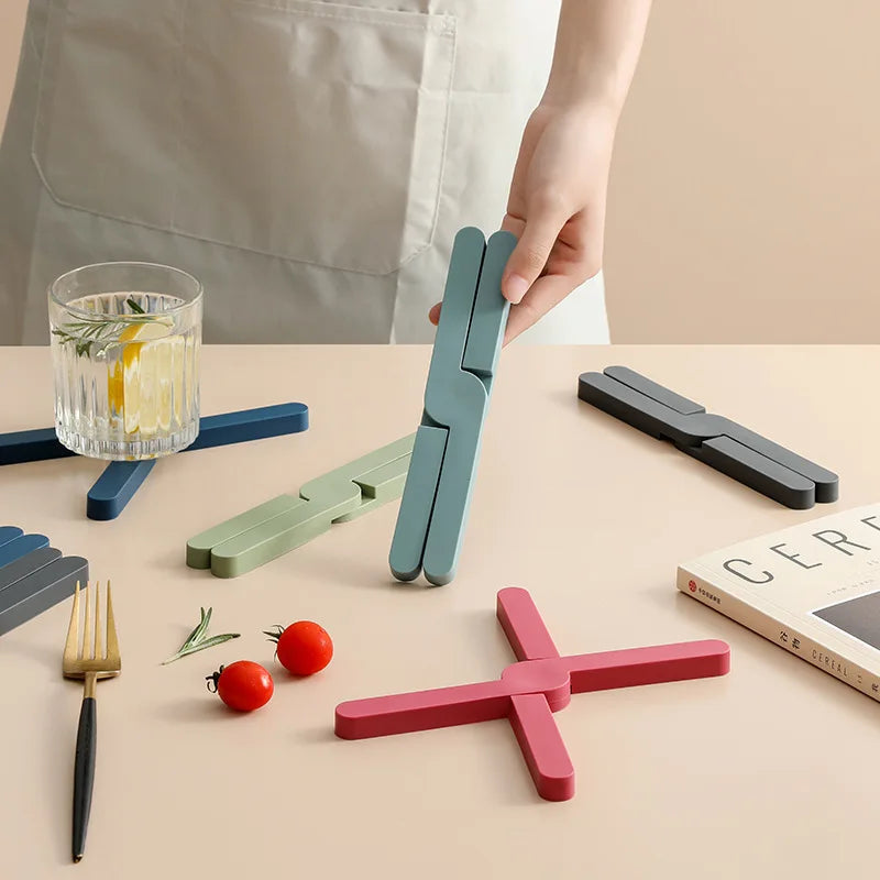 Folded and open silicone pot mats in several colors on a table
