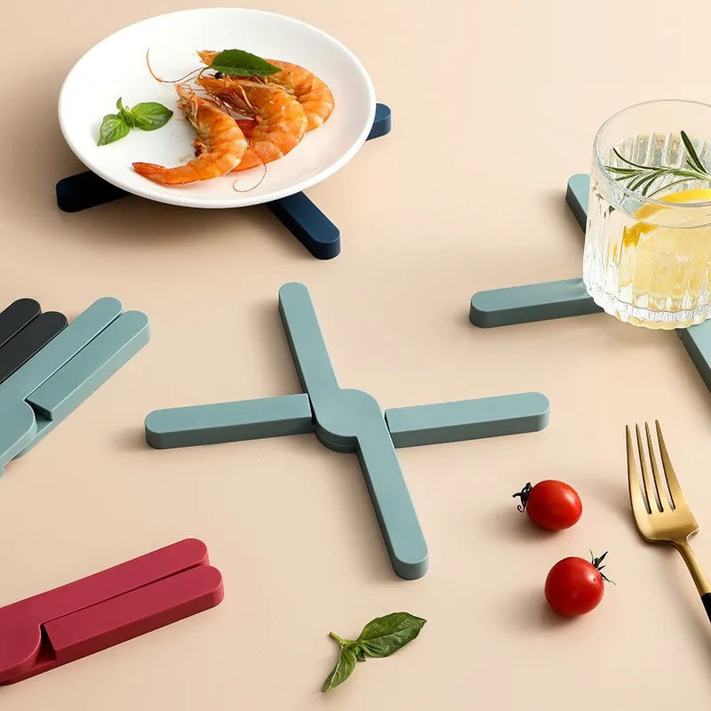 Folding silicone pot mats in several colors on a kitchen table